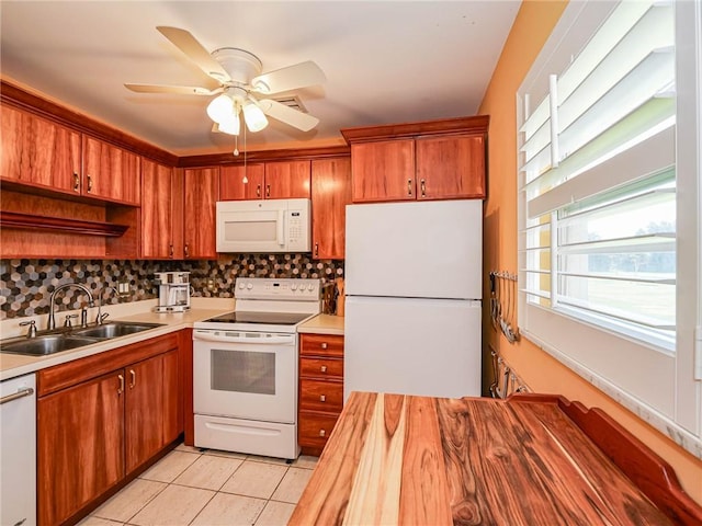 55 Woodland Dr Unit 206, Vero Beach, FL 32962 - kitchen featuring white appliances, a sink, decorative backsplash, a ceiling fan, and light tile patterned floors