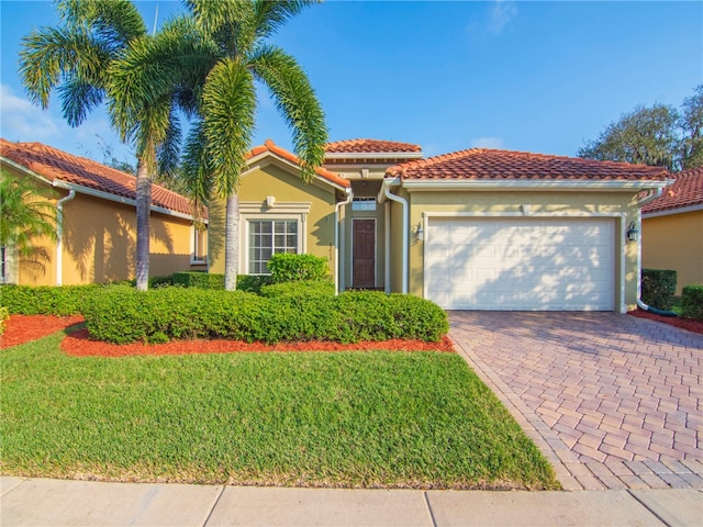 mediterranean / spanish home featuring a garage and a front lawn