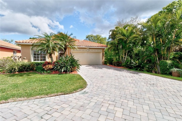 mediterranean / spanish-style home featuring a tiled roof, decorative driveway, an attached garage, and stucco siding