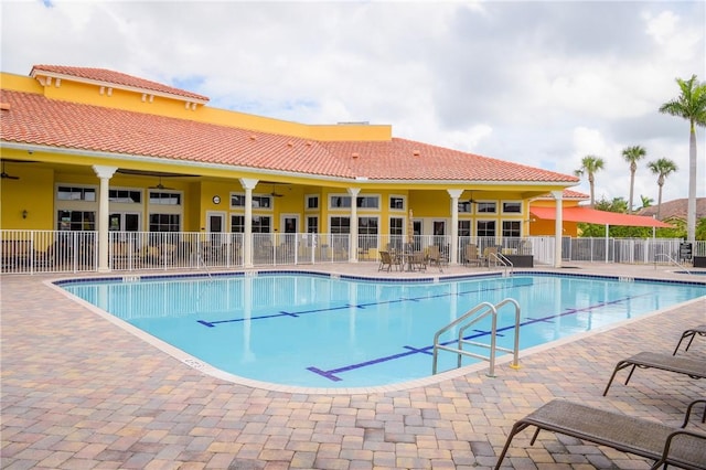 community pool with a patio area and fence