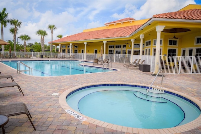 community pool with a ceiling fan, fence, and a patio