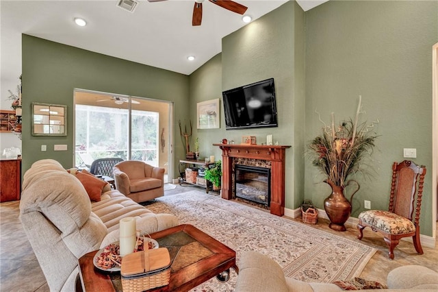 living room with a ceiling fan, a glass covered fireplace, vaulted ceiling, and baseboards