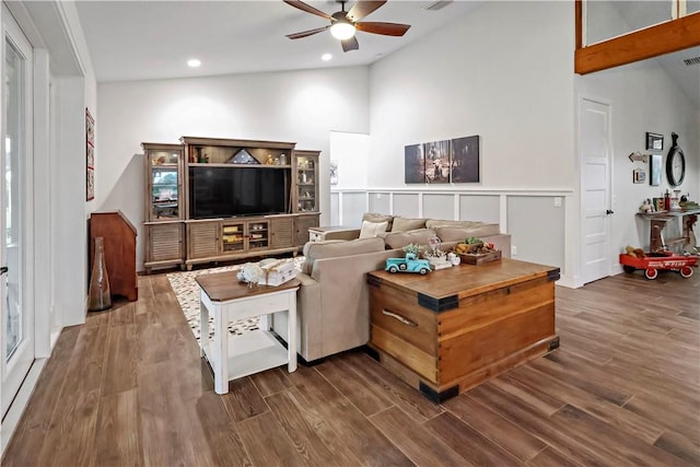 living room featuring ceiling fan, dark wood-type flooring, and vaulted ceiling