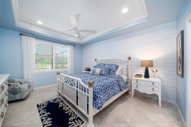 bedroom featuring a tray ceiling, ceiling fan, wood walls, and ornamental molding