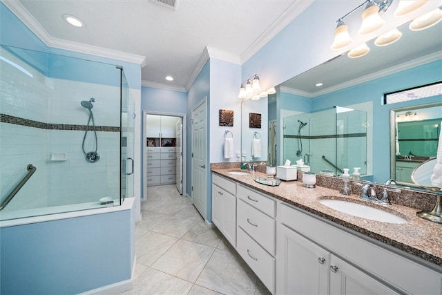 bathroom with vanity, a shower with shower door, and ornamental molding