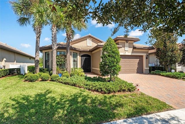 mediterranean / spanish-style home featuring a garage and a front lawn