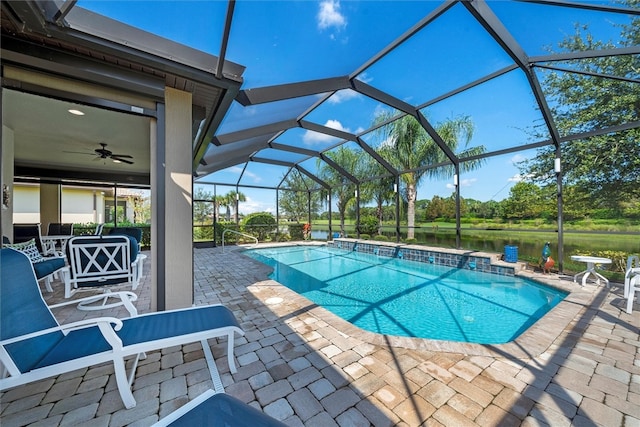 view of swimming pool featuring a lanai, a patio area, ceiling fan, and a water view