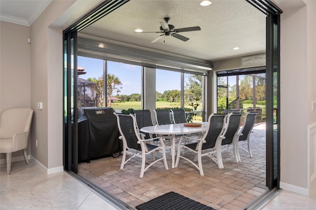 sunroom / solarium featuring ceiling fan