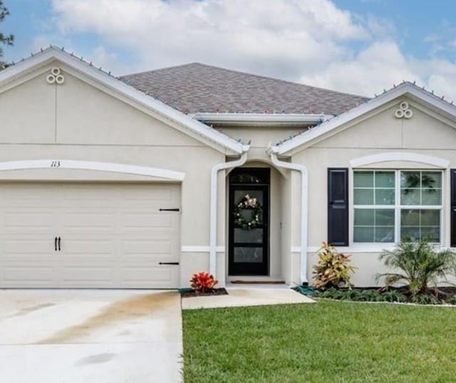 view of front of home with a front lawn and a garage