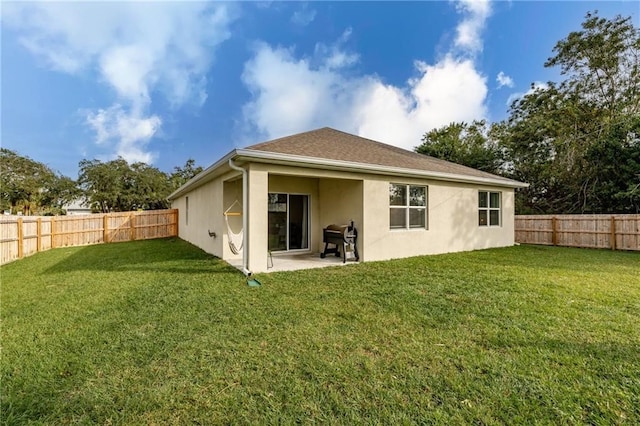 rear view of house featuring a patio area and a yard