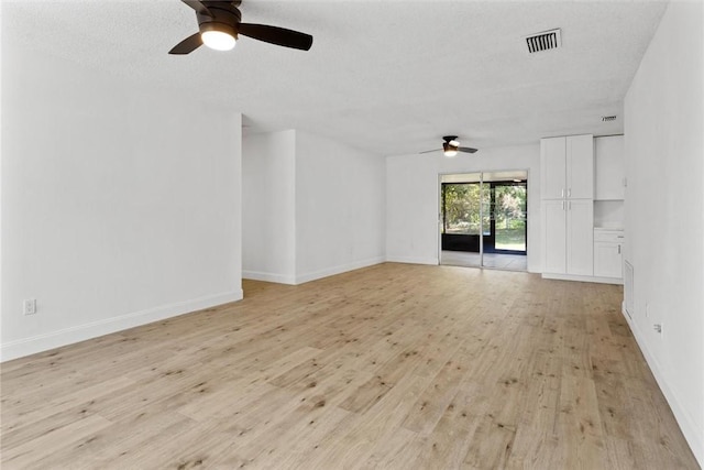 unfurnished living room featuring ceiling fan, a textured ceiling, and light wood-type flooring