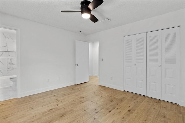 unfurnished bedroom with ensuite bathroom, ceiling fan, a textured ceiling, and light hardwood / wood-style flooring