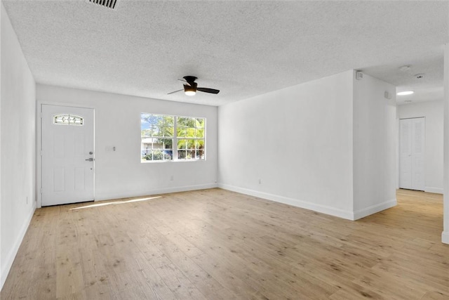 unfurnished living room featuring a textured ceiling, light wood-type flooring, and ceiling fan