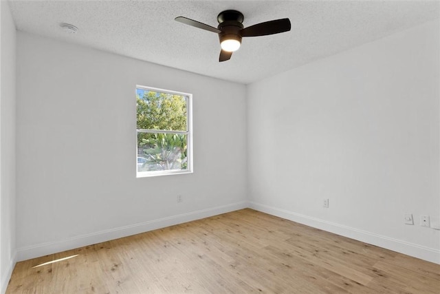 empty room with ceiling fan, a textured ceiling, and light wood-type flooring