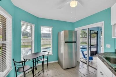 kitchen with white cabinetry, a healthy amount of sunlight, sink, and stainless steel refrigerator