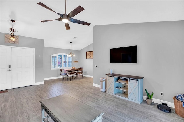 living room with wood-type flooring, lofted ceiling, and ceiling fan