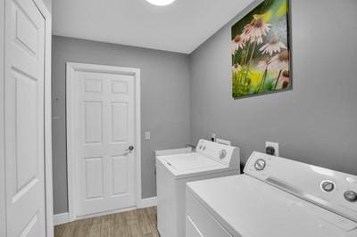 washroom with light hardwood / wood-style flooring and washer and dryer