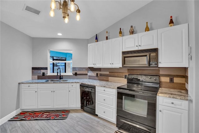 kitchen featuring sink, white cabinets, black appliances, light stone countertops, and light wood-type flooring