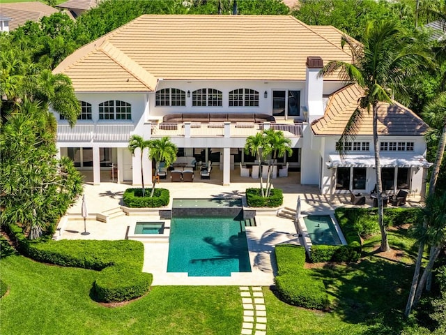 back of property with a patio, a balcony, stucco siding, and an outdoor hangout area