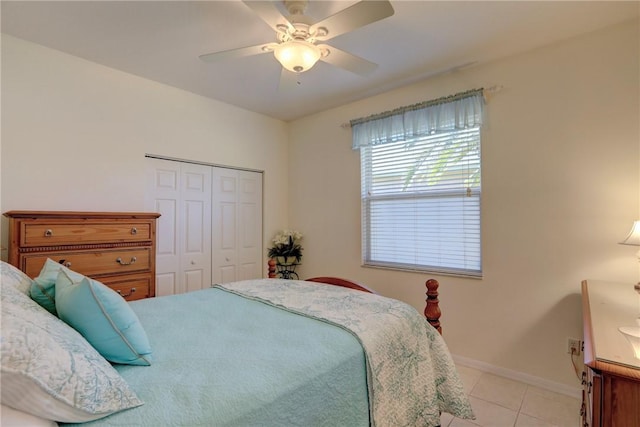 bedroom with light tile patterned floors, a closet, baseboards, and ceiling fan