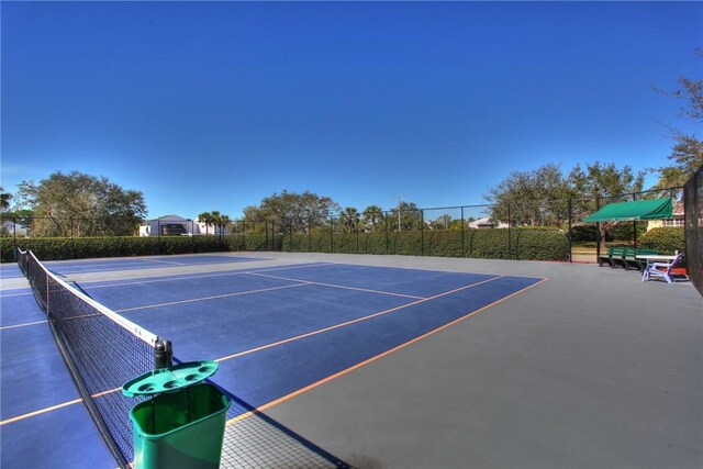 view of tennis court featuring fence