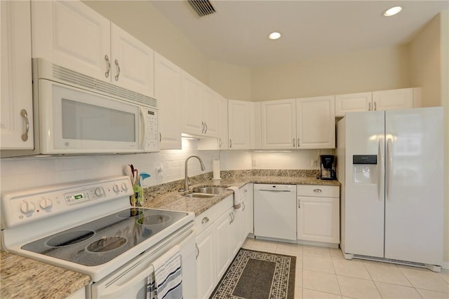 kitchen with visible vents, light tile patterned floors, white cabinets, white appliances, and a sink