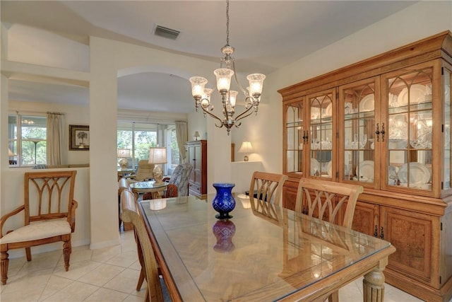 dining area with a wealth of natural light, visible vents, arched walkways, and light tile patterned floors