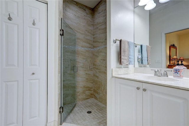 full bathroom with vanity, a stall shower, and a closet