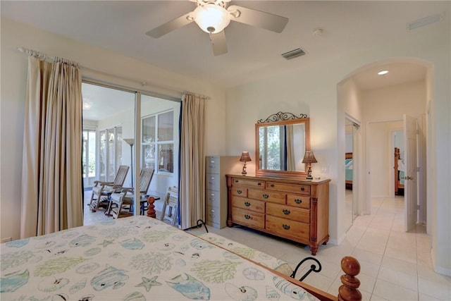 bedroom with a ceiling fan, light tile patterned floors, arched walkways, and visible vents