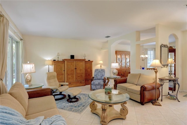 living room with a chandelier, arched walkways, plenty of natural light, and light tile patterned flooring