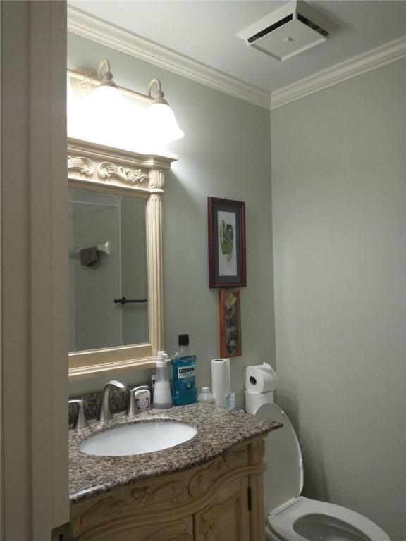 bathroom with toilet, vanity, and ornamental molding