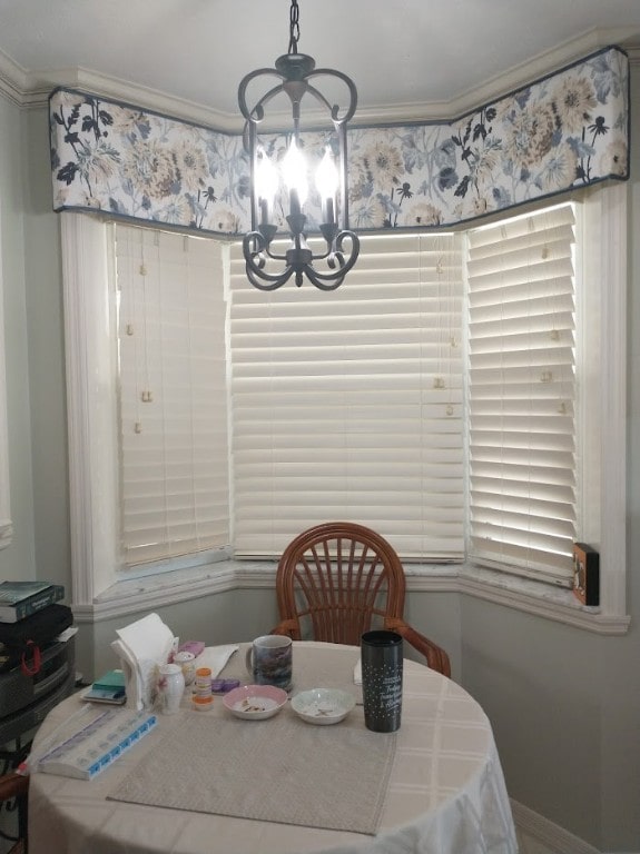 dining room with ornamental molding and a notable chandelier