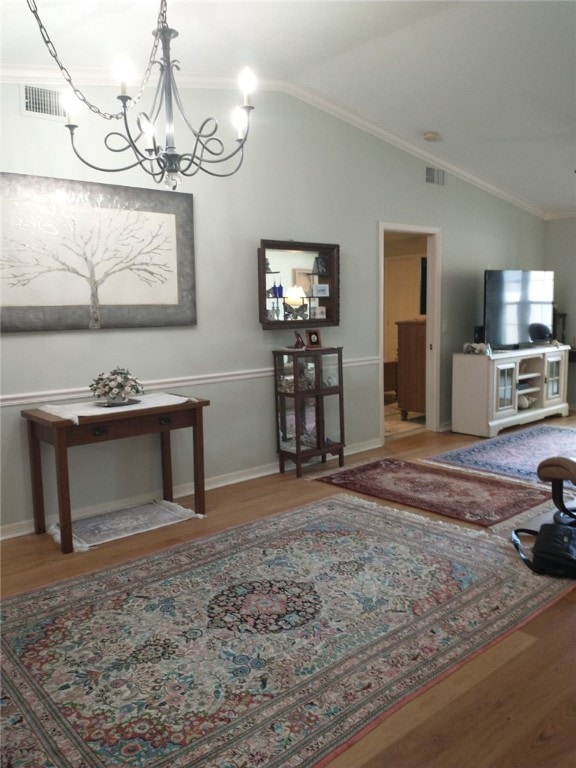 dining space featuring hardwood / wood-style flooring, vaulted ceiling, crown molding, and a notable chandelier