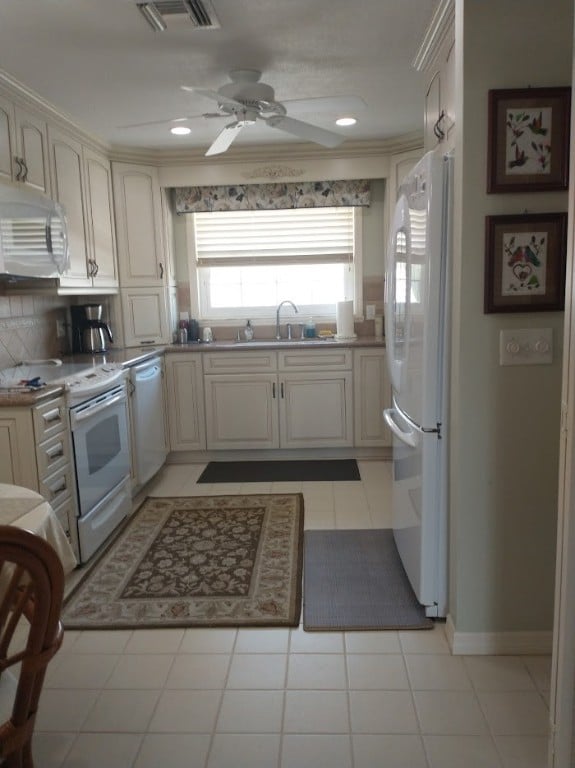 kitchen with white appliances, sink, tasteful backsplash, cream cabinetry, and light tile patterned flooring