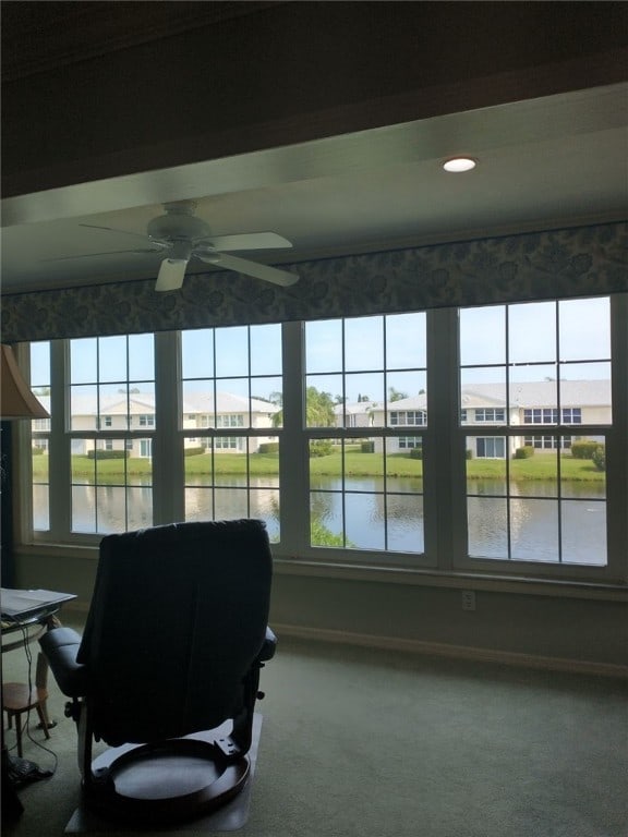 sunroom with ceiling fan, a healthy amount of sunlight, and a water view