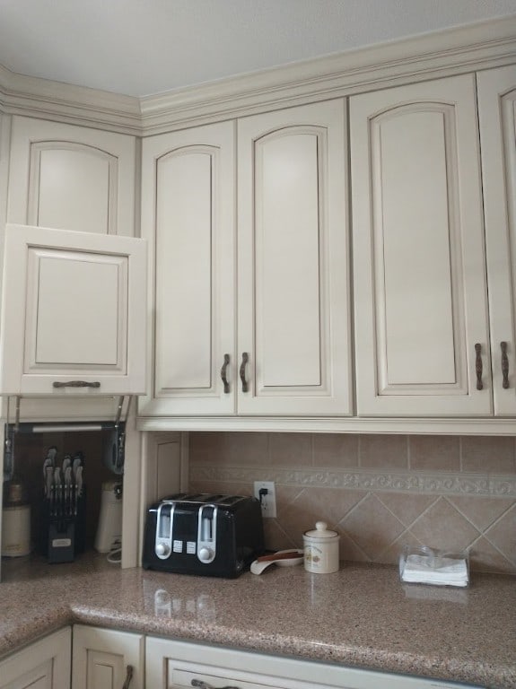 kitchen featuring backsplash and cream cabinets