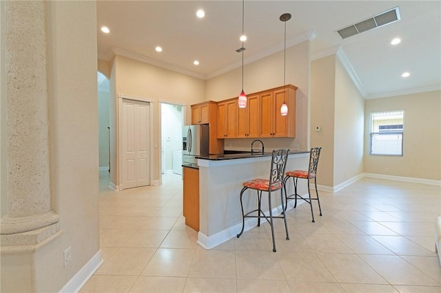 6124 57th Ct, Vero Beach, FL 32967 - kitchen featuring stainless steel fridge, ornamental molding, light tile patterned flooring, a breakfast bar, and dark countertops