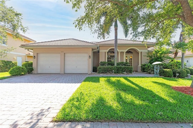 6124 57th Ct, Vero Beach, FL 32967 - view of front of house featuring a front yard, an attached garage, stucco siding, and decorative driveway