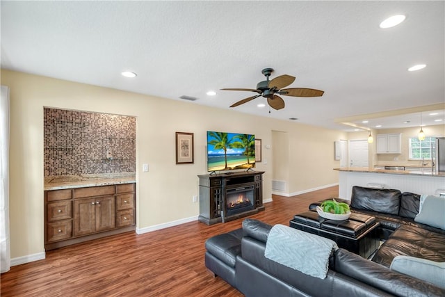 living room featuring wood-type flooring and ceiling fan