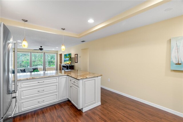 kitchen with white cabinetry, dark hardwood / wood-style flooring, stainless steel fridge, kitchen peninsula, and pendant lighting