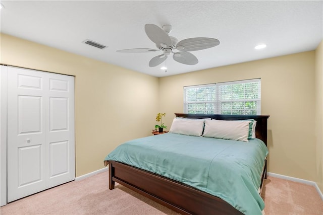 bedroom featuring light carpet, a closet, and ceiling fan