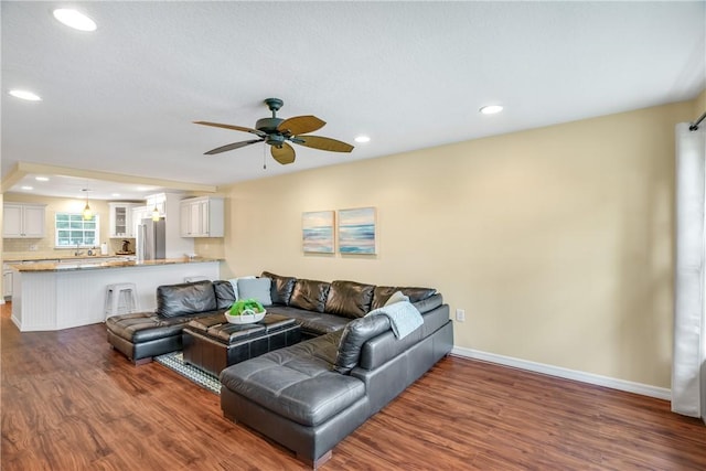 living room featuring dark hardwood / wood-style flooring and ceiling fan