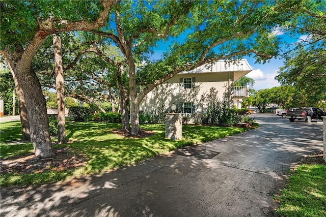 view of front of property featuring a balcony and a front lawn