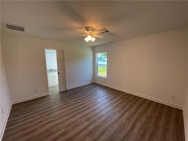 empty room with a textured ceiling, dark wood-type flooring, and ceiling fan