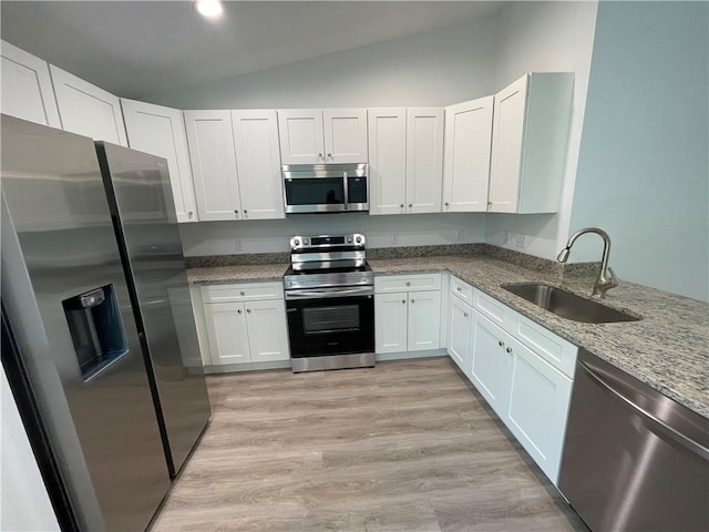 kitchen featuring sink, white cabinets, light stone counters, light hardwood / wood-style floors, and stainless steel appliances