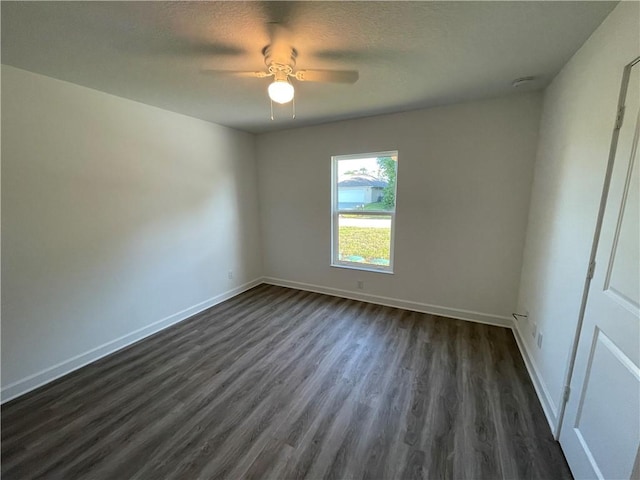 empty room featuring dark wood-type flooring, a textured ceiling, and ceiling fan