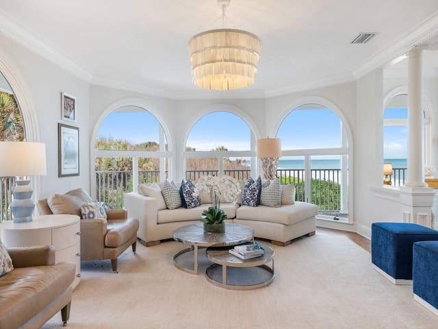 living room featuring an inviting chandelier, ornate columns, and ornamental molding