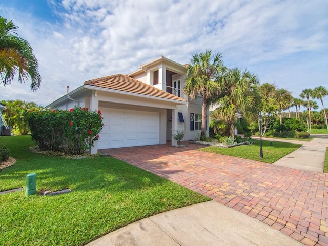 view of front of home featuring a garage, a front yard, and a balcony