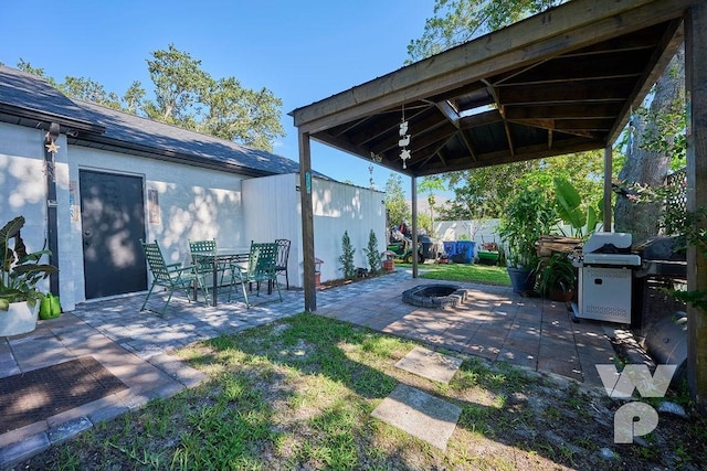 view of patio / terrace with an outdoor fire pit, a grill, a gazebo, and fence