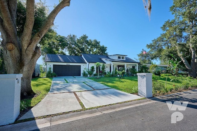 view of front facade with an attached garage, concrete driveway, and a front yard